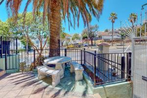 a table and two benches in front of a fence at Beautiful Spacious House 2BR / 4BR in Silver Terrace in San Francisco