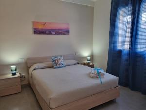 1 dormitorio pequeño con 1 cama y cortinas azules en Realmonte Casa vacanze Realbeach en Realmonte