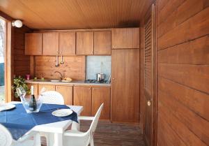 una cucina e una sala da pranzo con tavolo e sedie di Villaggio Camping Calapineta a Siniscola