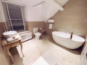 a bathroom with a tub and a sink and a toilet at Olif in Betws-y-coed