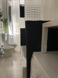 La salle de bains blanche est pourvue de toilettes et d'un lavabo. dans l'établissement Carpenino's home, à La Spezia