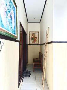 a hallway with a staircase and a painting on the wall at Bali Laksita Homestay in Canggu