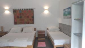 Habitación pequeña con 2 camas y mesa. en Orchidia House Santa Fe Bantayan Island en Bantayan Island
