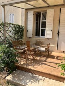 a wooden deck with two chairs and a bench at Charmant appartement cosy in Saint-Raphaël