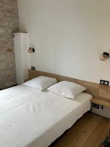 a bedroom with a white bed with two pillows at Charmant appartement cosy in Saint-Raphaël