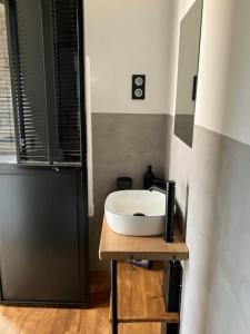 a bathroom with a white sink on a wooden table at Charmant appartement cosy in Saint-Raphaël