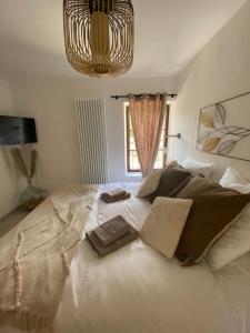 1 dormitorio con 1 cama blanca grande con lámpara de araña en L’auberge de Montsalier en Le Plan
