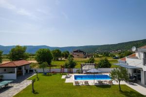 a house with a yard with a swimming pool at NEW Villa Anja is a 4 bedroom villa with a 32 sqm heated pool near Imotski in Imotski