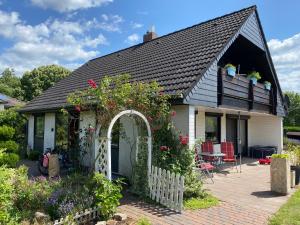 ein Haus mit einem Garten und einem weißen Zaun in der Unterkunft Fewo Zerbe Adendorf in Adendorf