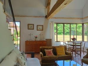 un soggiorno con un divano e un tavolo di Maison de Charme en Sologne avec Étang Privé, Grand Parc et Cheminée - FR-1-586-37 a Sainte-Montaine