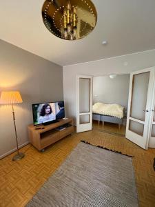 - un salon avec une télévision et un lit dans l'établissement Valimontien residenssi, à Kouvola