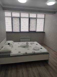 uma cama grande num quarto com janelas em Студия №2-65 LifeHouseAlmaty в ЖК Теремки-2 em Almaty