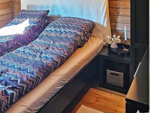 uma cama com um edredão e almofadas em Holiday home lyngdal IX em Lyngdal