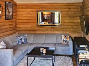 uma sala de estar com um sofá e uma mesa em Holiday home lyngdal IX em Lyngdal