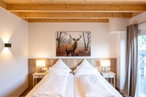 2 camas en un dormitorio con una foto de un ciervo en la pared en Landhotel Ewerts, en Insul