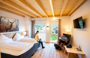 Dos personas sentadas en una habitación de hotel con dos camas en Landhotel Ewerts, en Insul