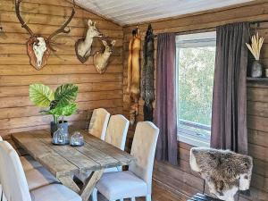 uma sala de jantar com uma mesa de madeira e cadeiras em Holiday home lyngdal IX em Lyngdal
