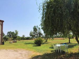 a table and chairs under a tree in a field at Chez Lucy&Nico in Verfeil