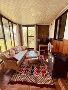 a living room with a couch and a tv at Avocado Cottages in Khadkagaon