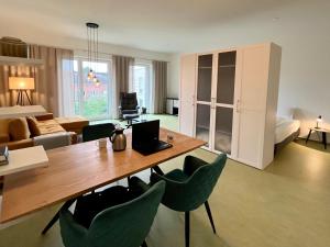 a living room with a table and green chairs at Appartements Haus Augustinus in Münster