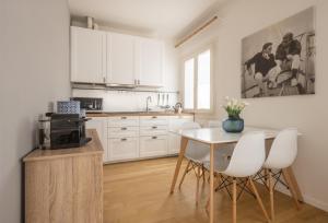 cocina con armarios blancos, mesa y sillas en Santa Croce Design Apartment R&R, en Venecia