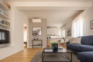 un soggiorno con un divano blu e un tavolo di Santa Croce Design Apartment R&R a Venezia