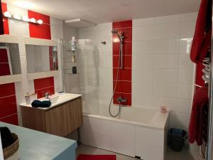 La salle de bains est pourvue d'une douche, d'un lavabo et d'une baignoire. dans l'établissement Appart Terre Mer Deauville, à Bonneville-sur-Touques