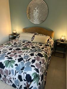 a bedroom with a bed with a floral bedspread at Appart Terre Mer Deauville in Bonneville-sur-Touques