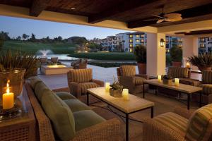 eine Terrasse mit Sofas und Tischen sowie einen Golfplatz in der Unterkunft Arizona Grand Resort in Phoenix