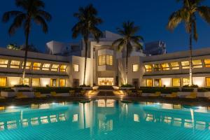 a hotel with a swimming pool at night at Trident Bhubaneswar in Bhubaneshwar