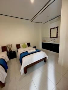 a bedroom with two beds and a mirror at Bali Laksita Homestay in Canggu