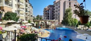 a swimming pool in a resort with people sitting in chairs at Sunny Beach Hills Apartment - Private in Sunny Beach