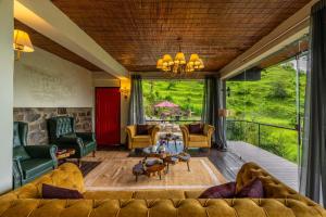 a living room with a couch and chairs at StayVista at Leopard's Creek with Pool in Solan