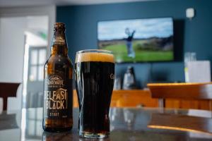 a bottle of beer sitting on a table with a glass at The Briers Country House in Newcastle