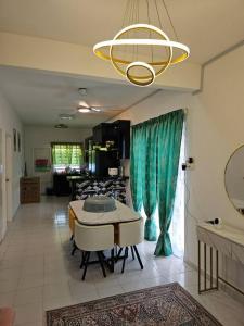 甘孟的住宿－Nafisa 3 Homestay，客厅配有桌椅和吊灯。
