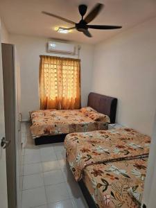 甘孟的住宿－Nafisa 3 Homestay，一间卧室配有两张床和吊扇
