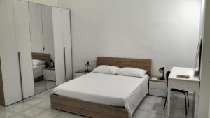 a bedroom with a bed and a desk and a mirror at Alloggio privato "Ballatoio233" in Bisceglie