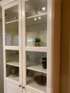 a white cabinet filled with dishes and dishes at Appartement met topligging in Zele