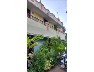 a building with a bunch of plants in front of it at R.K.Inn Guest House, Nonankuppam in Pūrnānkuppam