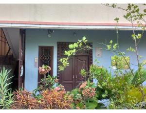 a house with a brown door and some plants at R.K.Inn Guest House, Nonankuppam in Pūrnānkuppam