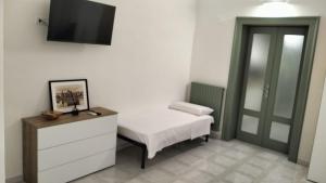 a bedroom with a bed and a tv on the wall at Alloggio privato "Ballatoio233" in Bisceglie