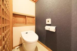 a bathroom with a toilet and two rolls of toilet paper at Fuji Onsenji Yumedono in Fujikawaguchiko