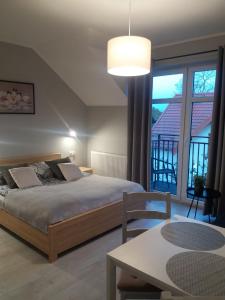 ein Schlafzimmer mit einem Bett und einem großen Fenster in der Unterkunft WILLA AMBER in Ostrowo