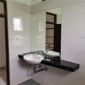 a bathroom with two sinks and a large mirror at The Grove in Kandy