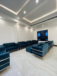 a large room with blue couches and a flat screen tv at Awadh Samrat Resort in Ayodhya