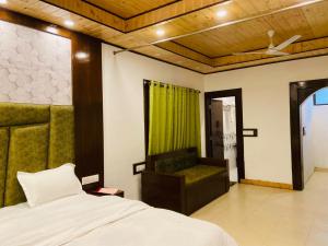una camera con un letto e un divano di StudioZ Paradise Hills Mussoorie a Mussoorie