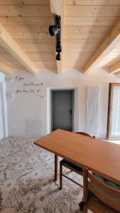 a dining room with a wooden table and a ceiling at Maison Annabelle in Ceniga