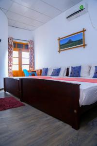 Canal Side Guest House Polonnaruwa في بولوناروا: غرفة نوم بسرير كبير في غرفة