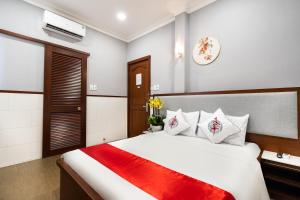 een slaapkamer met een groot wit bed en een rode deken bij Văn Hoa Hotel in Ho Chi Minh-stad