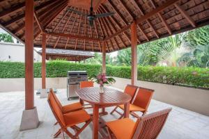 un patio avec une table et des chaises sous un pavillon dans l'établissement The Residence Villa 203, à Bang Tao Beach